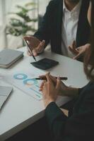 Financial analysts analyze business financial reports on a digital tablet planning investment project during a discussion at a meeting of corporate showing the results of their successful teamwork. photo