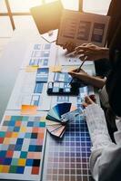 Close up ux developer and ui designer brainstorming about mobile app interface wireframe design on table with customer breif and color code at modern office.Creative digital development agency photo