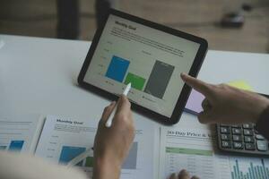 Financial analysts analyze business financial reports on a digital tablet planning investment project during a discussion at a meeting of corporate showing the results of their successful teamwork. photo