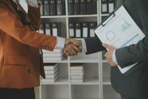 Group of confident business people point to graphs and charts to analyze market data, balance sheet, account, net profit to plan new sales strategies to increase production capacity. photo