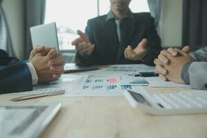 Group of confident business people point to graphs and charts to analyze market data, balance sheet, account, net profit to plan new sales strategies to increase production capacity. photo