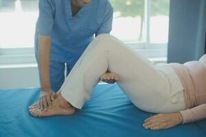 young asian physical therapist working with senior woman on walking with a walker photo