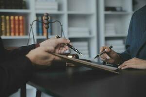 Business and lawyers discussing contract papers with brass scale on desk in office. Law, legal services, advice, justice and law concept picture with film grain effect photo