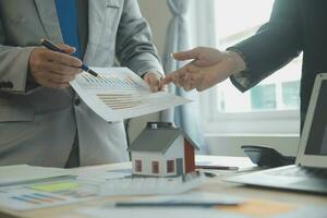 Group of confident business people point to graphs and charts to analyze market data, balance sheet, account, net profit to plan new sales strategies to increase production capacity. photo