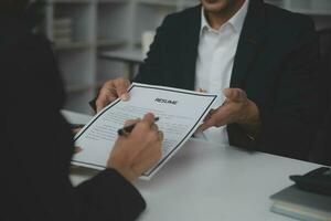 Close up view of job interview in office, focus on resume writing tips, employer reviewing good cv of prepared skilled applicant, recruiter considering application, hr manager making hiring decision photo