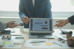 Group of confident business people point to graphs and charts to analyze market data, balance sheet, account, net profit to plan new sales strategies to increase production capacity. photo