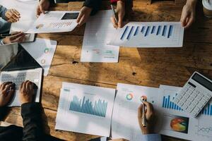 Financial analysts analyze business financial reports on a digital tablet planning investment project during a discussion at a meeting of corporate showing the results of their successful teamwork. photo