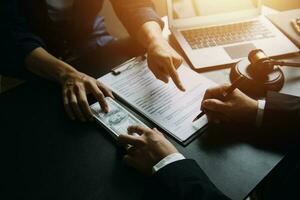 Business and lawyers discussing contract papers with brass scale on desk in office. Law, legal services, advice, justice and law concept picture with film grain effect photo