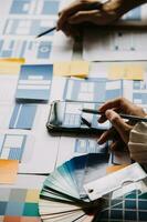 Close up ux developer and ui designer brainstorming about mobile app interface wireframe design on table with customer breif and color code at modern office.Creative digital development agency photo