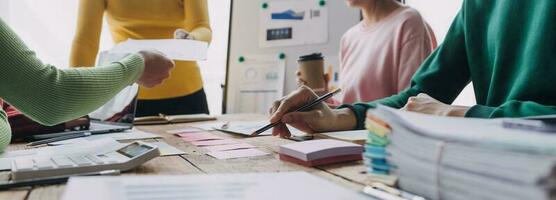 Brainstorming Collaboration and successful partnership analysis by Young business Asian people working in an office workspace photo