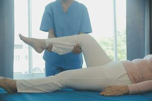 Doctor or physical therapist examines back pain and spinal area to give advice within the rehabilitation center. photo