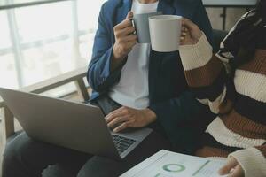 Group of confident business people point to graphs and charts to analyze market data, balance sheet, account, net profit to plan new sales strategies to increase production capacity. photo