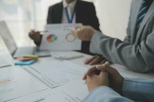 Financial analysts analyze business financial reports on a digital tablet planning investment project during a discussion at a meeting of corporate showing the results of their successful teamwork. photo