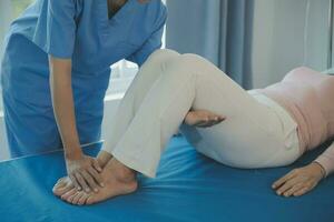 young asian physical therapist working with senior woman on walking with a walker photo