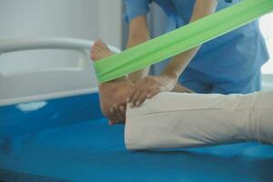 young asian physical therapist working with senior woman on walking with a walker photo