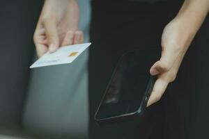 cerca arriba de mujer mano utilizando crédito tarjeta y ordenador portátil para pago y en línea compras, en línea compras, pagos digital bancario, comercio electrónico concepto. foto