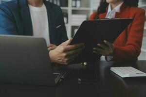 Group of confident business people point to graphs and charts to analyze market data, balance sheet, account, net profit to plan new sales strategies to increase production capacity. photo