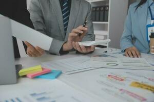 los analistas financieros analizan los informes financieros de negocios en un proyecto de inversión de planificación de tabletas digitales durante una discusión en una reunión de empresas que muestran los resultados de su exitoso trabajo en equipo. foto