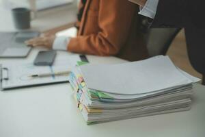Group of confident business people point to graphs and charts to analyze market data, balance sheet, account, net profit to plan new sales strategies to increase production capacity. photo