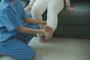 young asian physical therapist working with senior woman on walking with a walker photo