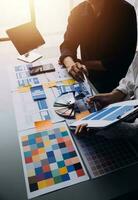 Close up ux developer and ui designer brainstorming about mobile app interface wireframe design on table with customer breif and color code at modern office.Creative digital development agency photo