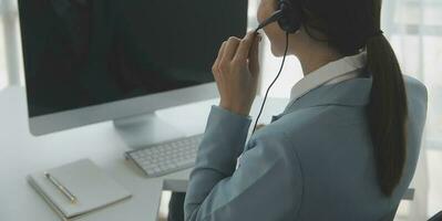 Young friendly operator woman agent with headsets working in a call centre. photo