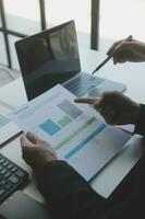 Financial analysts analyze business financial reports on a digital tablet planning investment project during a discussion at a meeting of corporate showing the results of their successful teamwork. photo