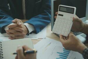Group of confident business people point to graphs and charts to analyze market data, balance sheet, account, net profit to plan new sales strategies to increase production capacity. photo
