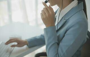 Young friendly operator woman agent with headsets working in a call centre. photo