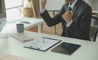 Group of confident business people point to graphs and charts to analyze market data, balance sheet, account, net profit to plan new sales strategies to increase production capacity. photo