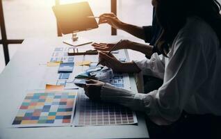 Close up ux developer and ui designer brainstorming about mobile app interface wireframe design on table with customer breif and color code at modern office.Creative digital development agency photo