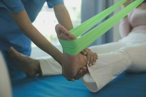 Doctor or physical therapist examines back pain and spinal area to give advice within the rehabilitation center. photo