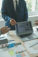 Group of confident business people point to graphs and charts to analyze market data, balance sheet, account, net profit to plan new sales strategies to increase production capacity. photo