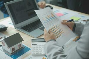 Group of confident business people point to graphs and charts to analyze market data, balance sheet, account, net profit to plan new sales strategies to increase production capacity. photo
