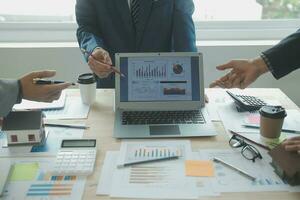 Group of confident business people point to graphs and charts to analyze market data, balance sheet, account, net profit to plan new sales strategies to increase production capacity. photo
