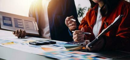 Close up ux developer and ui designer brainstorming about mobile app interface wireframe design on table with customer breif and color code at modern office.Creative digital development agency photo