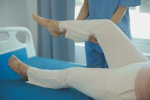 Doctor or physical therapist examines back pain and spinal area to give advice within the rehabilitation center. photo