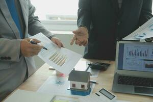 Group of confident business people point to graphs and charts to analyze market data, balance sheet, account, net profit to plan new sales strategies to increase production capacity. photo