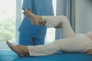 Doctor or physical therapist examines back pain and spinal area to give advice within the rehabilitation center. photo