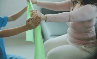 young asian physical therapist working with senior woman on walking with a walker photo