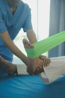 young asian physical therapist working with senior woman on walking with a walker photo