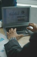 Group of confident business people point to graphs and charts to analyze market data, balance sheet, account, net profit to plan new sales strategies to increase production capacity. photo