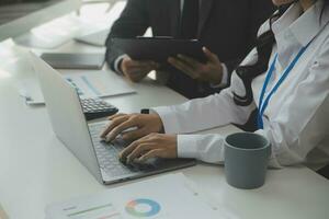 Group of confident business people point to graphs and charts to analyze market data, balance sheet, account, net profit to plan new sales strategies to increase production capacity. photo