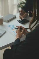 Financial analysts analyze business financial reports on a digital tablet planning investment project during a discussion at a meeting of corporate showing the results of their successful teamwork. photo