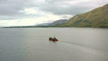 A Commercial Ship is Seen Traversing A Sea Loch in Scotland video