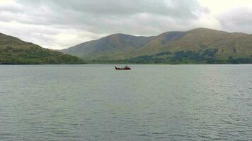 uma comercial navio é visto atravessando uma mar lago dentro Escócia video