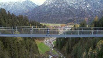 niña cruce un puente peatonal abarcando un barranco en Suiza video