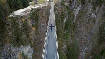 Girl Crossing a Footbridge Spanning a Ravine video