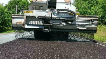 pesado maquinaria ressurgindo uma estrada usando micro asfalto vestir video