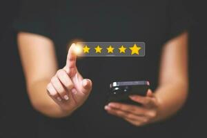 Customer pressing satisfaction with gold five star rating feedback icon and press level excellent rank for giving best score point to review the service , experience success business rate  concept. photo